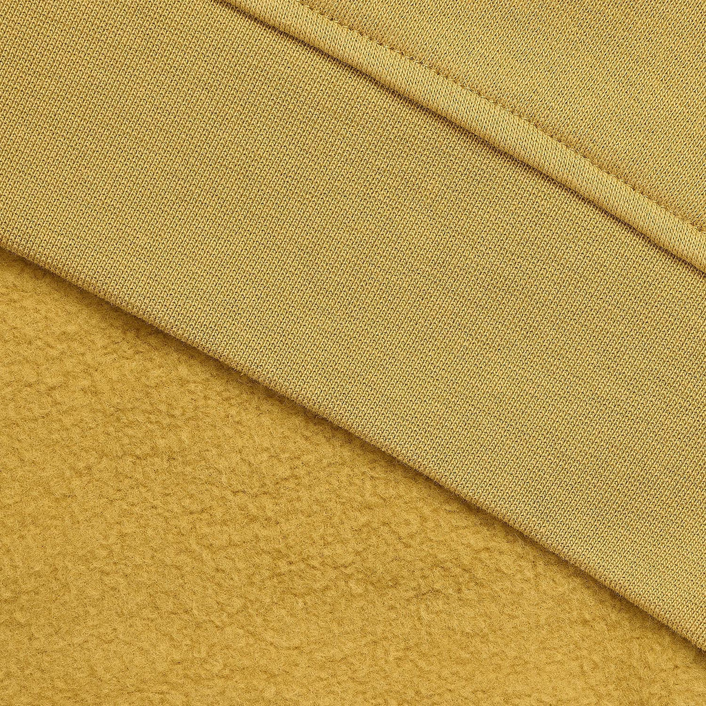 Close-up of a mustard yellow fabric texture with a ribbed knit band and a plush fleece-like section below it.