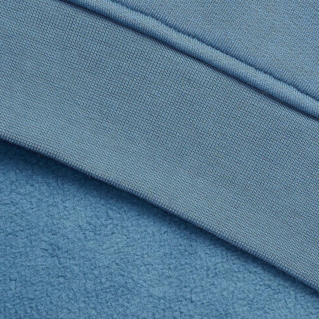 Close-up of a dusty blue textured fabric with a diagonal ribbed seam.