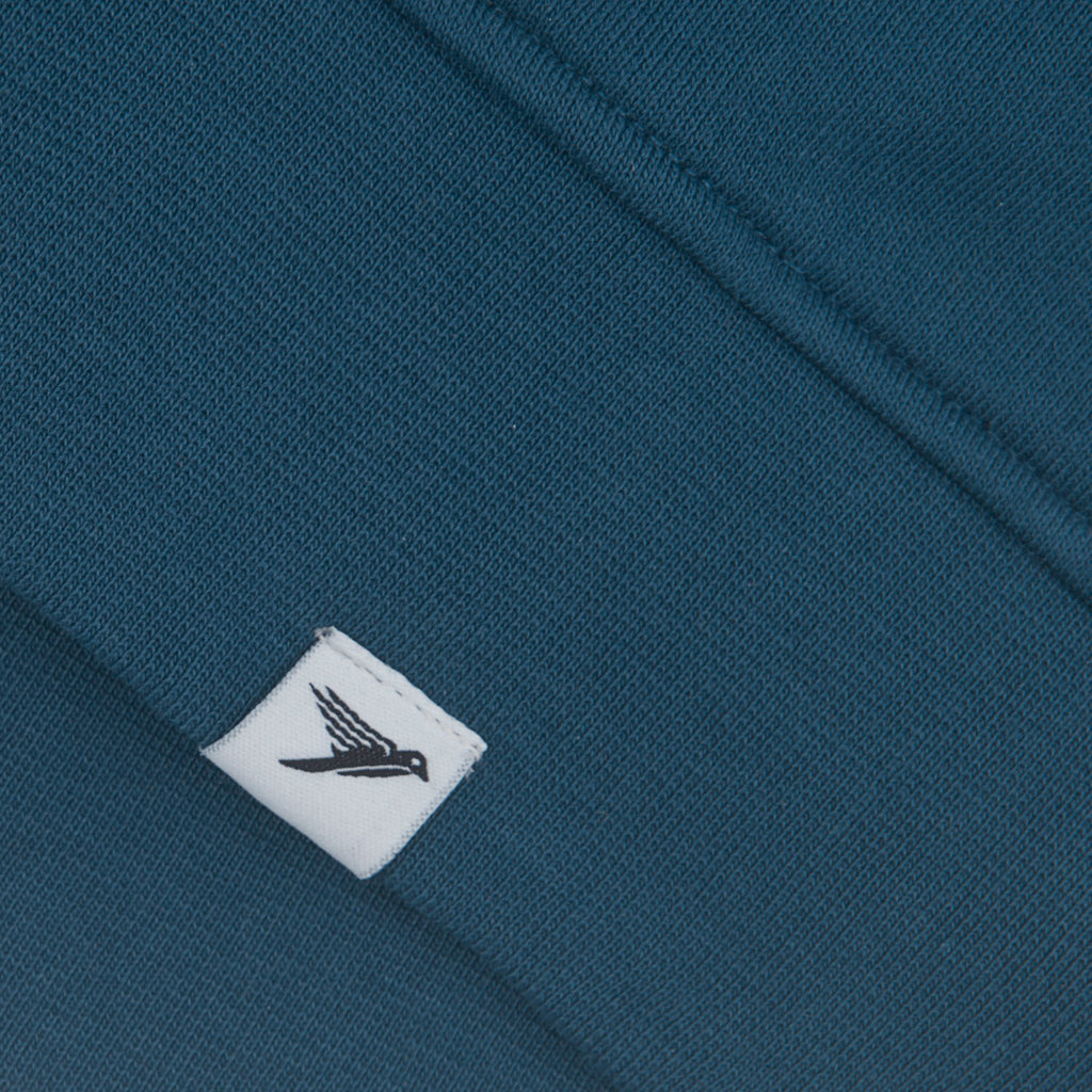 Close-up of a blue fabric with a white label featuring a black logo.