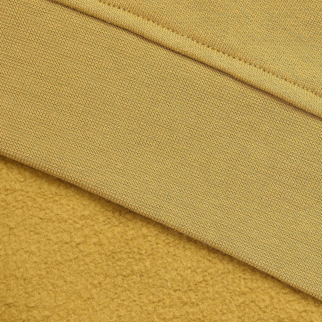 Close-up of a mustard yellow fabric with a ribbed knit texture and a soft fleece-like layer folded over.